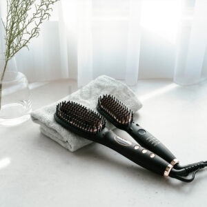 カーテン窓際にテーブルを配置し自然光の逆行で撮影した電動ヘアブラシの商品イメージ画像