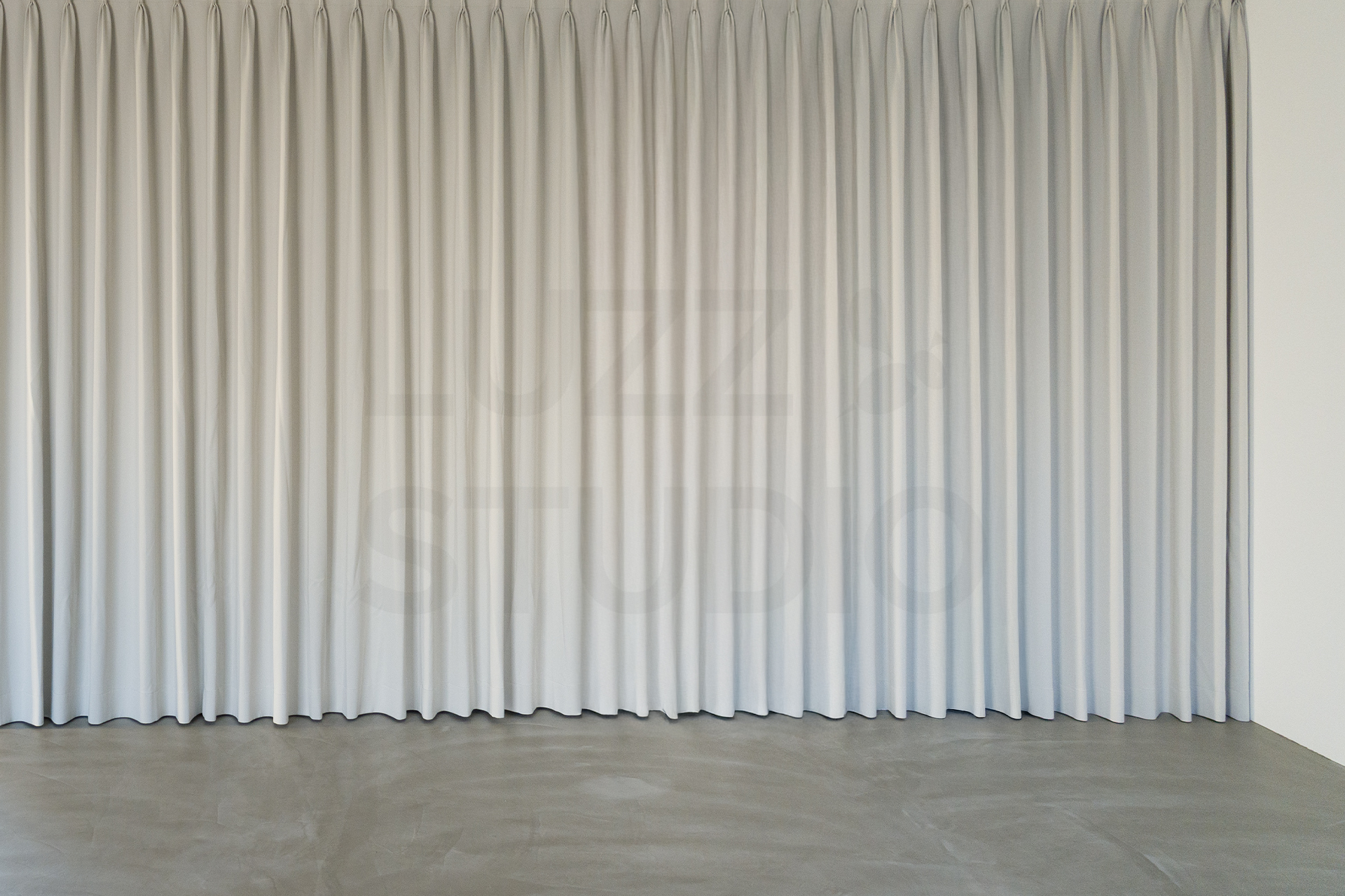 大阪のレンタル撮影スタジオ。モルタルグレーの床と、柔らかなアイボリーのカーテンを配したミニマルな背景エリア
