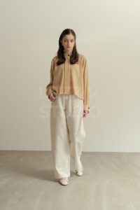 阪の撮影会社によるアパレルカタログ撮影。白壁とモルタル床のモダンな空間で、モデルの魅力を引き出すスタイリッシュなファッションフォト