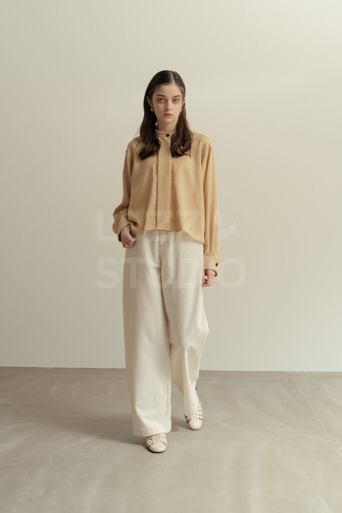 阪の撮影会社によるアパレルカタログ撮影。白壁とモルタル床のモダンな空間で、モデルの魅力を引き出すスタイリッシュなファッションフォト