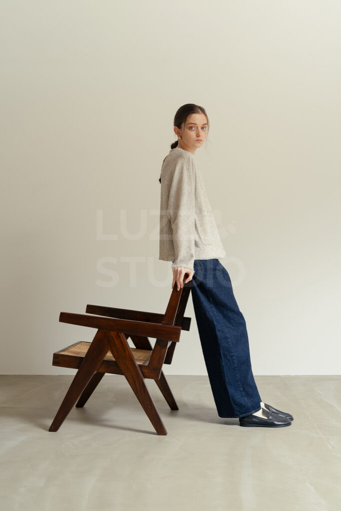 ジャンヌレやYチェアを配したアパレル撮影シーン。家具を活用することで、モデルのポージングに変化をつけ、単調にならないカタログ写真を