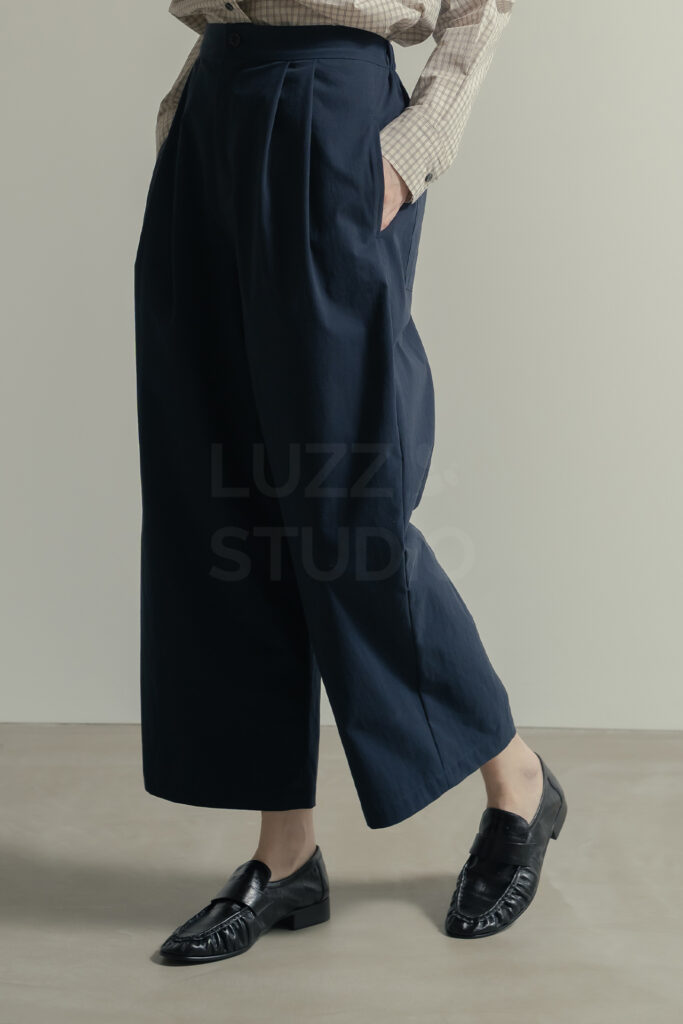 白壁モルタルグレー壁のシチュエーションでボトムの詳細をとらえたＥＣアパレルのモデル撮影写真