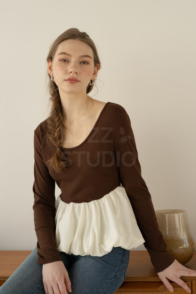 ラズスタジオの常設家具のサイドボードの前でポーズをとる女性モデルのレディスアパレルEC撮影写真