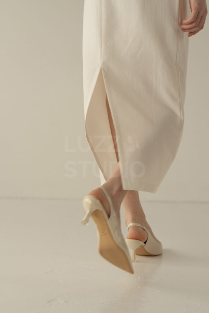 白壁白床の背景でスカートのベンツ部分を撮影した歩くモデルの一瞬を撮影したレディスアパレルEC撮影写真